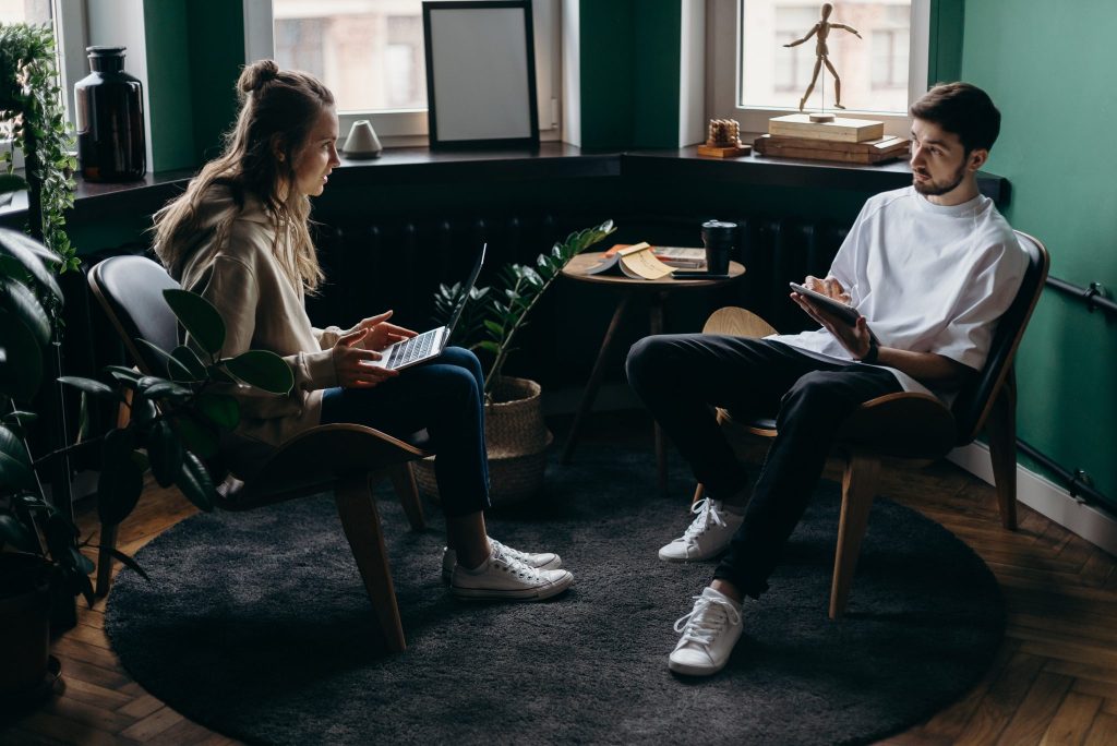 Songwriting session with artists playing guitar in a relaxed studio