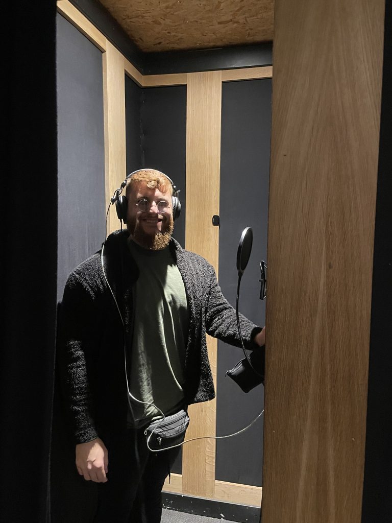 Singer recording vocals with headphones in the vocal booth
