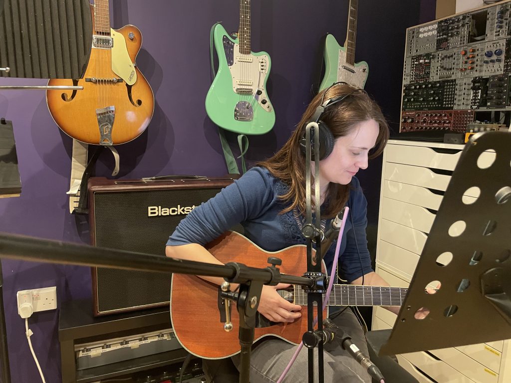 Artist recording acoustic guitar and vocals